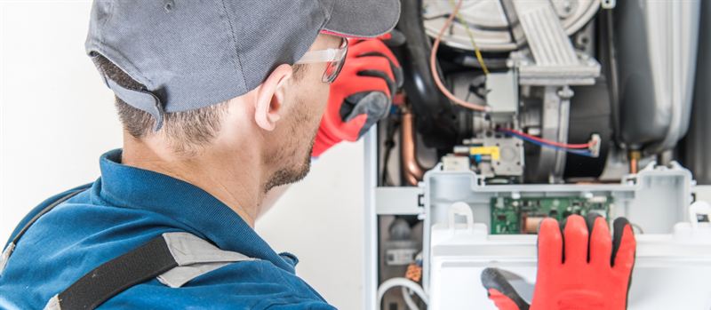 Gas engineer working on a commercial boiler in Loughborough | Gas Main Installation Gas engineer working on a commercial boiler in Loughborough