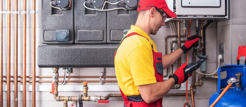 Engineer taking gas test readings beside a boiler in Carlisle | Gas Main Installation Engineer taking gas test readings beside a boiler in Carlisle