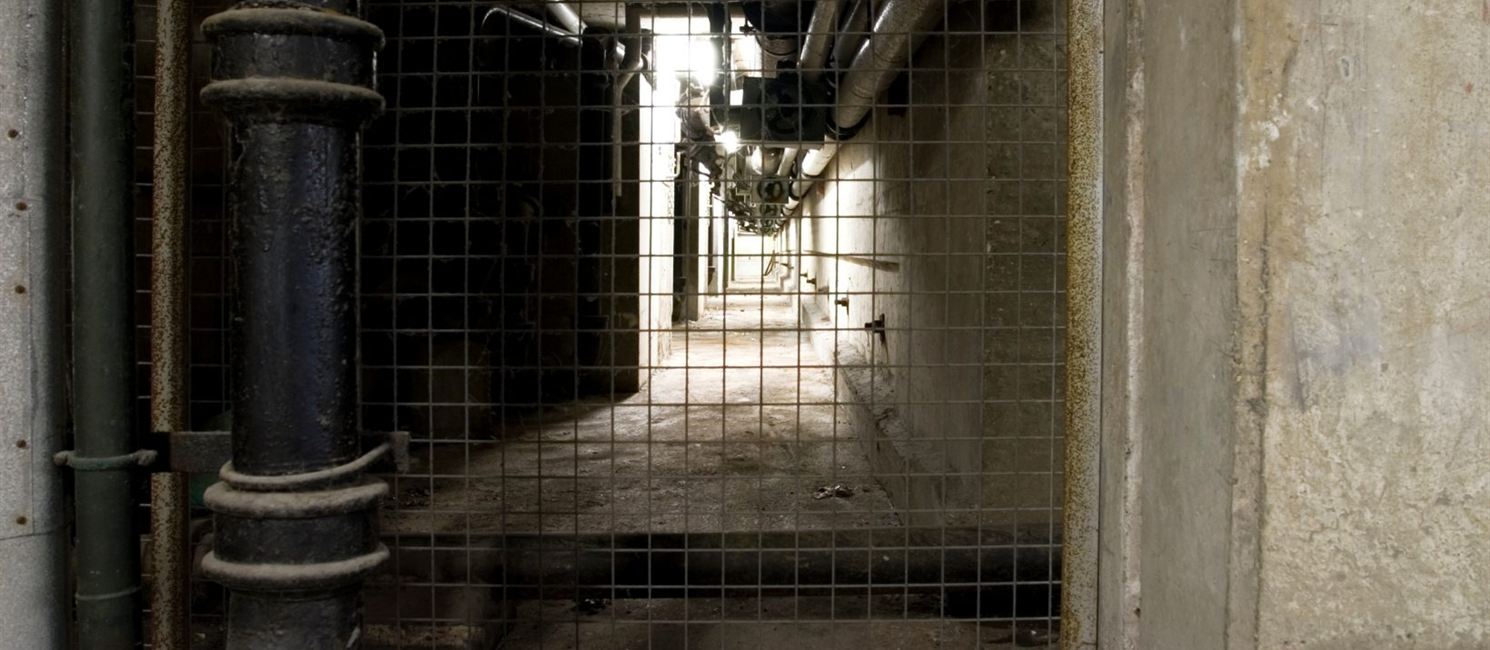 Old gas pipework in a basement service corridor in Liverpool